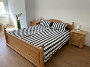 ビンツにあるFerienwohnung in VILLA AMANDA/ Whg. 9のベッドルーム1室(黒と白のストライプの木製ベッド1台付)