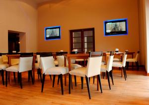 Toscano Hotel في رافاييلا: غرفة طعام مع طاولة وكراسي بيضاء
