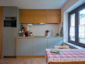 una cocina con armarios blancos y una mesa en una habitación en New flat in Bormio - Centrale 69 en Piatta