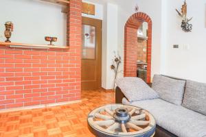 a living room with a couch and a brick wall at Holiday House Radovna Bled in Zgornje Gorje
