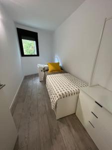 a small bedroom with a bed with a yellow pillow at Nuevo, espacioso y confortable con pkg y piscina in Tossa de Mar +29 photos