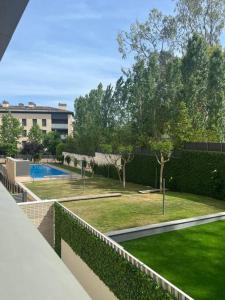 a view of a garden with a swimming pool and a building at Nuevo, espacioso y confortable con pkg y piscina in Tossa de Mar