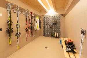 uma sala com esquis e equipamento de esqui na parede em Brenta Rosso - Charme Apartments em Fai della Paganella