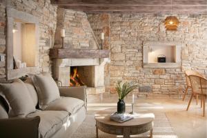 ein Wohnzimmer mit einem Sofa und einer Steinmauer in der Unterkunft Residence Pietre d'Istria - with private service in Burići