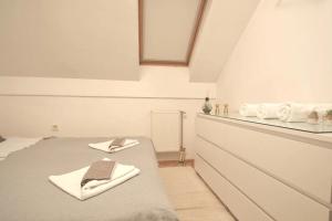a white room with a bed with towels on it at Spacious 1-bedroom apartment in Novi Sad