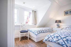 a bedroom with two beds and a desk and a window at Haus-Twesk-Merre in Munkmarsch