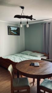 1 dormitorio con mesa, cama, mesa y sillas en Czapla siwa, en Sztutowo