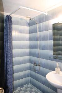 a blue tiled bathroom with a sink and a shower at Kotza Ntere in Axioúpolis +38 photos