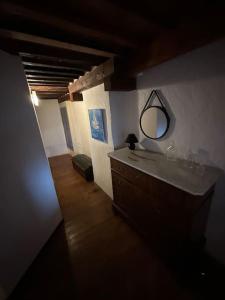 een badkamer met een wastafel en een spiegel aan de muur bij maison à la campagne in Quinson
