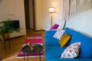 een woonkamer met een blauwe bank en een tafel bij Lika's apartment with a marvelous view in Tbilisi City