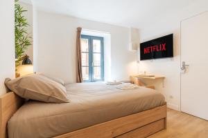- un lit dans une chambre avec un panneau mural dans l'établissement Le Cocon - Netflix/Wifi Fibre - Séjour Lozère, à Mende