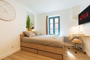 a bedroom with a bed and a clock on the wall at Le Cocon - Netflix/Wifi Fibre - Séjour Lozère in Mende