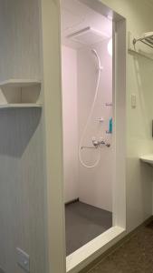 W łazience znajduje się prysznic ze szklanymi drzwiami. w obiekcie 阪南国际HOTEL w mieście Hannan
