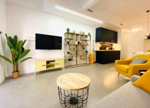 sala de estar con sofá amarillo y mesa en RUALVA FLATS, Tarongers, en Valencia