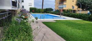 a backyard with a swimming pool and a yard with flowers at lovecosta apartamento sur in Torremolinos