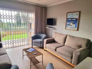 a living room with a couch and a chair at 20 Brandersig in Jeffreys Bay