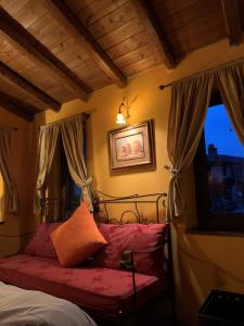 um quarto com uma cama com almofadas cor-de-rosa e uma janela em Ippoliti em Palaioi Poroi