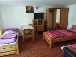 a bedroom with two beds and a table and a mirror at Agroturystyka Jacnia in Jacnia