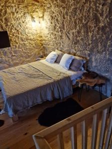 a bedroom with a bed in a stone wall at Gardunha Stone in Louriçal do Campo