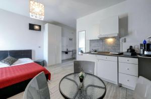 a room with a bed and a table and a kitchen at Garda Relais Luna Blu in Peschiera del Garda