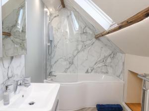 een badkamer met een wit bad en een wastafel bij Bluefin Cottage in Whitby +24 foto's