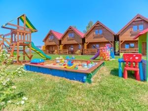a yard full of play equipment in front of a house at Cottage in Niechorze near Baltic Sea Beach in Niechorze