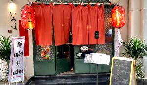 a restaurant with red curtains in front of a door at Nanwa House in Ho Chi Minh City