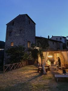 Vicopisano的住宿－Torre medievale Balducci，一群坐在城堡前椅子上的人