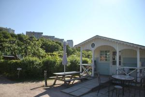 a small house with a picnic table and an umbrella at Candy-Colored Two-Room Condo with Sweet views in Helsinki