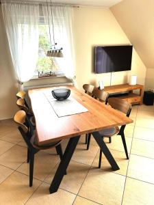 オストゼーバート・ディアーハーゲンにあるSEESTERN App Nr 12 max 6 Persのダイニングルーム(木製テーブル、椅子付)
