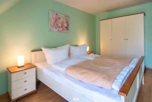 オストゼーバート・ディアーハーゲンにあるSEESTERN App Nr 12 max 6 Persのベッドルーム1室(大型ベッド1台、ドレッサー、ナイトスタンド付)