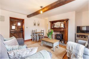 a living room with a couch and a table at Woodrow End Cottage in Cawston