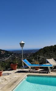 una piscina con una silla y una mesa en Mas des Buscades en Cabris