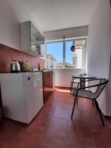 a kitchen with a table and a chair in a room at Apartmani Hortenzija in Budva