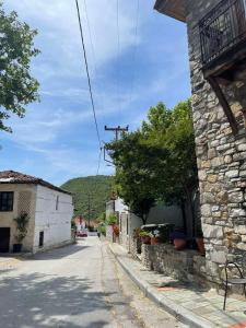 a street in a village with a stone building at Exohi apartments in Vrasná