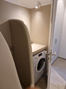 una lavanderia con lavatrice e asciugatrice di The Garden House a Città di Tinos