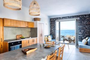 une cuisine avec une table et une vue sur l'océan dans l'établissement Mochlos Waterside, à Mochlos