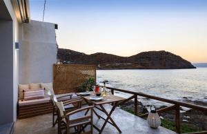 d'une table et de chaises sur un balcon donnant sur l'eau. dans l'établissement Mochlos Waterside, à Mochlos