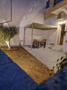 a patio with a table and awning on a building at The Garden House in Tinos
