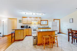 a kitchen with wooden cabinets and a white refrigerator at Sherry Road Retreat in South Burlington