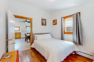 a bedroom with a white bed and a dining room at Sherry Road Retreat in South Burlington