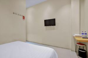 a white room with a bed and a tv at Vivostay in Medan