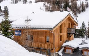 a log cabin with snow on the roof at Odalys Chalet Sporting Lodge in Plagne 1800