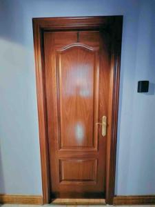 a wooden door in the corner of a room at Habitacion privado con baño privado en La Maresía in Cudillero