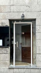 una ventana de un edificio con una puerta de cristal en Habitacion privado con baño privado en La Maresía, en Cudillero