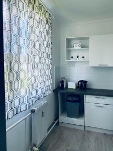 a kitchen with a table and a curtain in a room at Füred Apartman in Balatonfüred