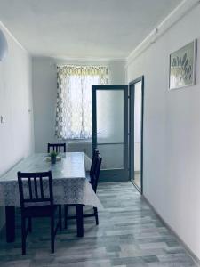 a dining room with a table and chairs and a window at Füred Apartman in Balatonfüred