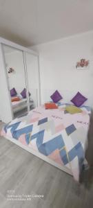 Bett mit farbenfroher Bettdecke in einem Zimmer in der Unterkunft Яркая квартира в стиле Поп Арт в центре города Караганда in Qaraghandy