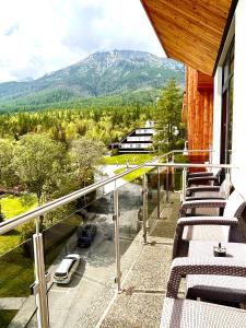 a balcony with chairs and a view of a mountain at Hotelový apartmán ALFRED C406 in Vysoke Tatry - Stary Smokovec