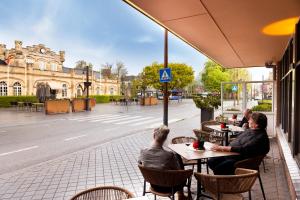 a group of people sitting at tables on a street at Dormio Wijnhotel Valkenburg in Valkenburg